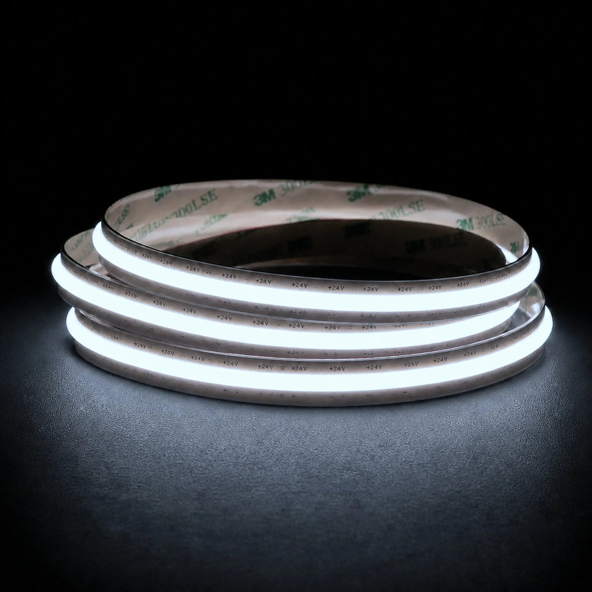 Cool White 6500K Free Cut COB LED strip coil illuminated on a dark background, 24V DC and 10mm wide.
