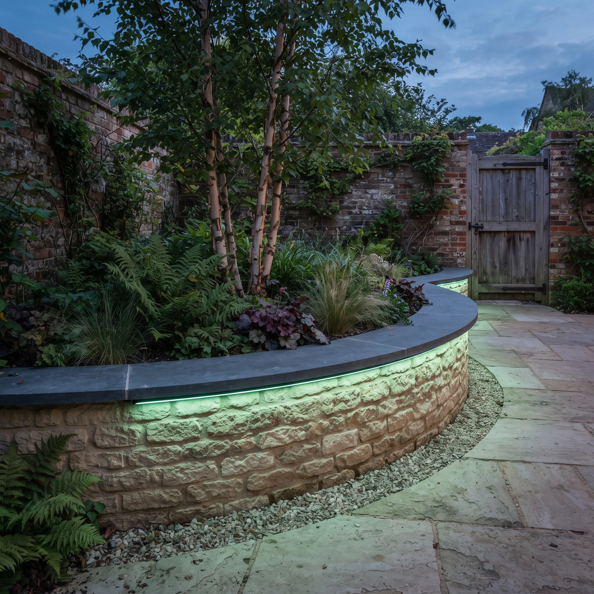 Green RGB neon flex curving horizontally beneath a garden planter coping and shining down