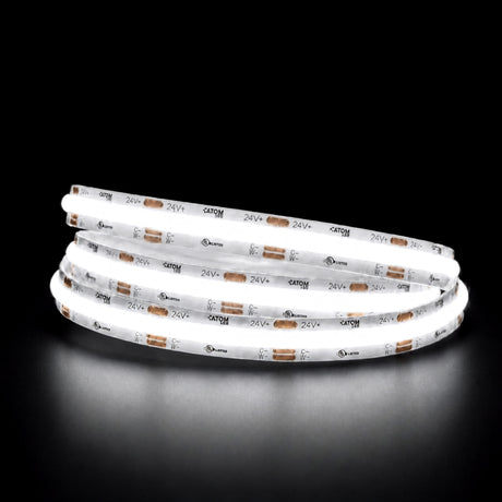 Daylight 5000K COB LED strip illuminated in a coil against a black background