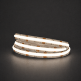 Natural white 4000K COB LED strip illuminated in a coil on a dark background