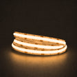 Warm white 2700K COB LED strip illuminated in a coil on a dark background