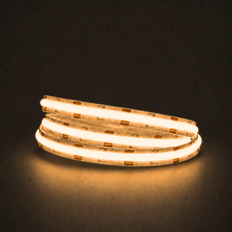 Warm white 2700K COB LED strip illuminated in a coil on a dark background