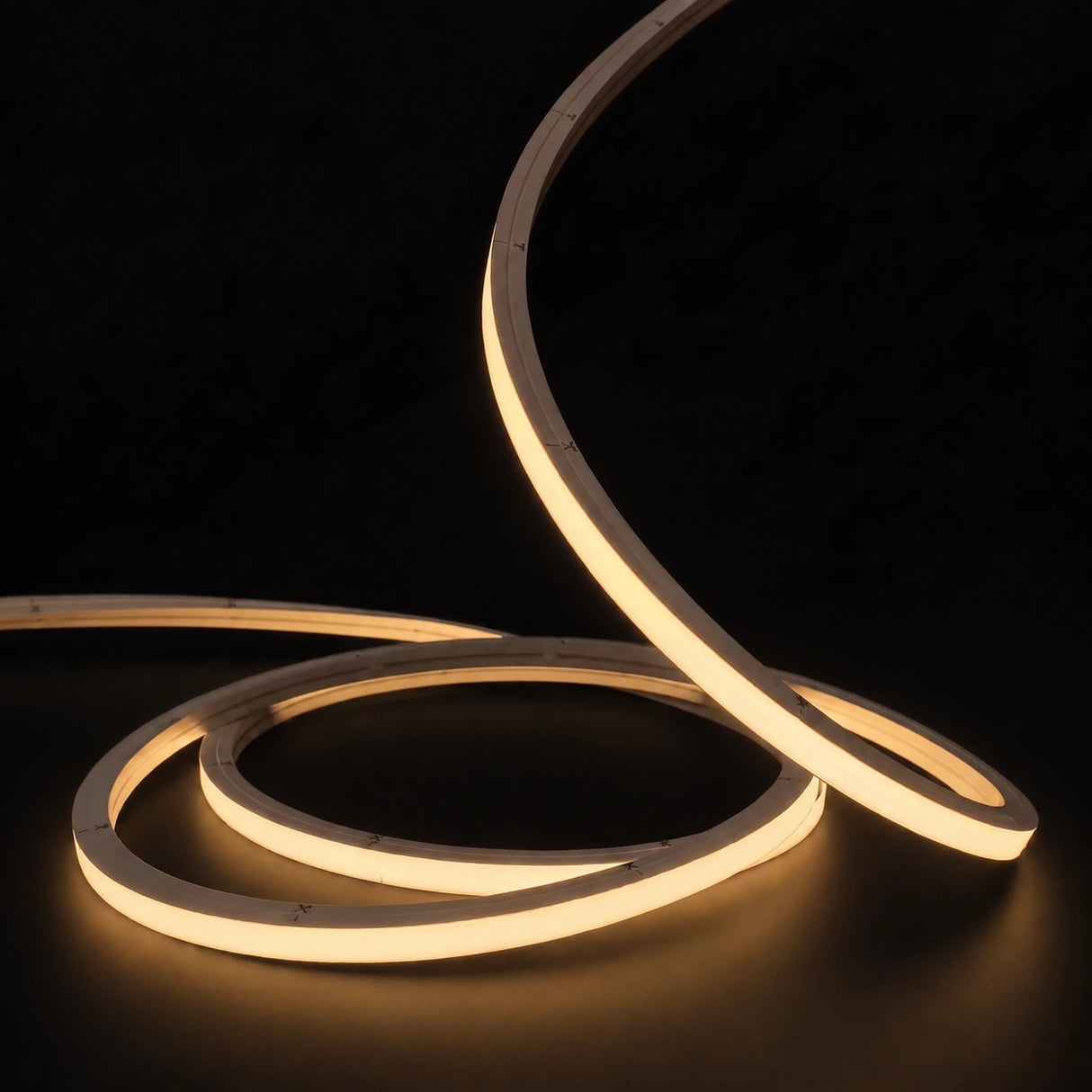 Warm White 2700K LED Neon Flex 15x15mm Top Bend 24V/48V, warm-white concentric coils with raised arc on a dark surface