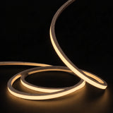 Warm White 2700K LED Neon Flex 15x15mm Top Bend 24V/48V, warm-white concentric coils with raised arc on a dark surface