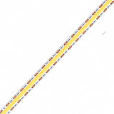ATOM LED 24V 10mm COB LED strip close-up with white PCB, copper contact pads and yellow phosphor