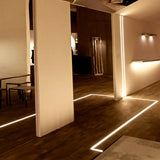 Black LED surface profile installed under a wall cabinet lighting a worktop