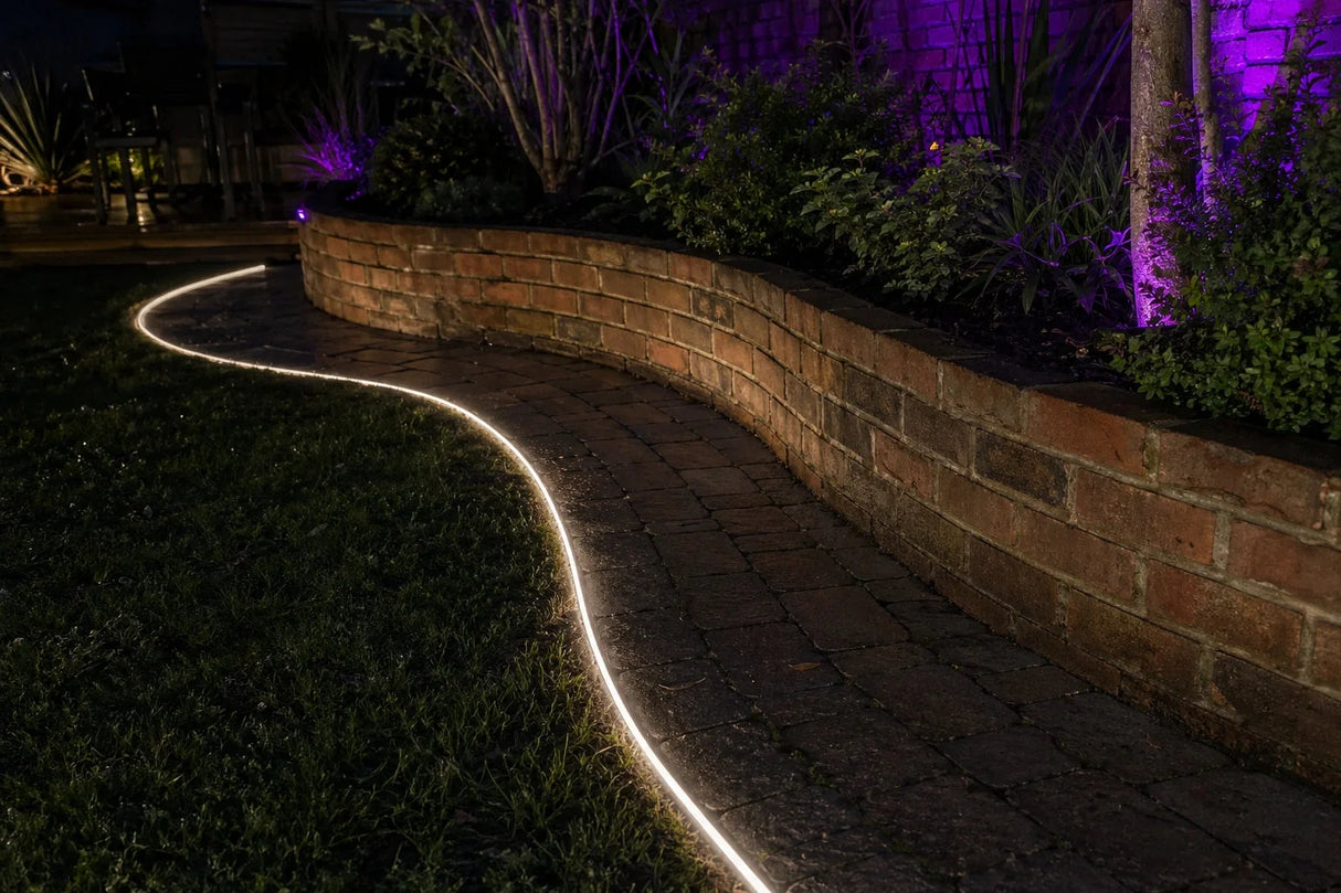 ATOM LED warm white 3000K 10x10mm side bend neon flex wrapping a curved outdoor garden border — 48V IP67 waterproof
