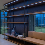 Blue dot-free LED strip lighting beneath dark-oak equipment shelves in a racquet sports club