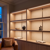 3000k white dot-free LED strip lighting beneath smoked-oak display shelving in a residential drawing room