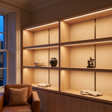 2700k white dot-free LED strip lighting beneath smoked-oak display shelving in a residential drawing room