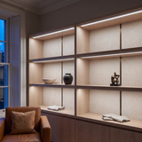 6500k white dot-free LED strip lighting beneath smoked-oak display shelving in a residential drawing room