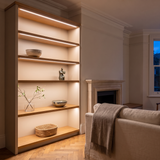 3000K white COB LED strip lighting beneath bespoke shelves in an elegant British home's sitting room