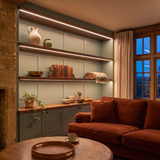 2700K white COB LED strip lighting beneath bespoke long display shelves in a beautiful British home