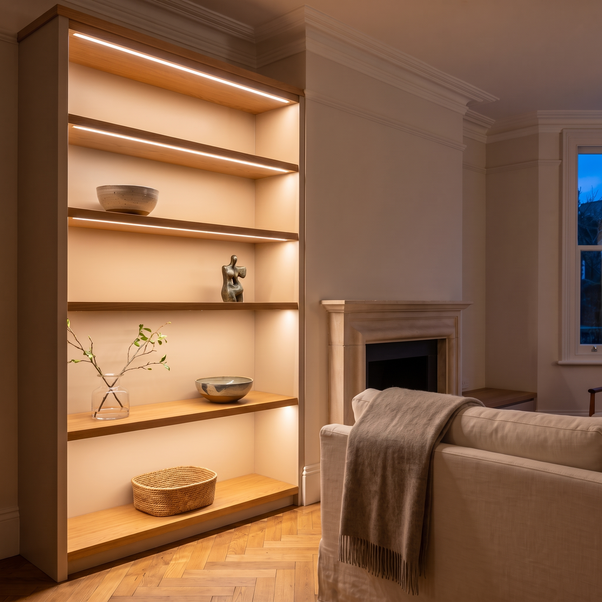 2700K white COB LED strip lighting beneath bespoke shelves in an elegant British home's sitting room