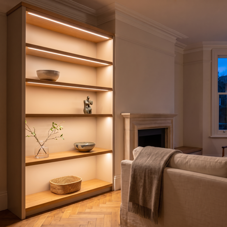 2700K white COB LED strip lighting beneath bespoke shelves in an elegant British home's sitting room