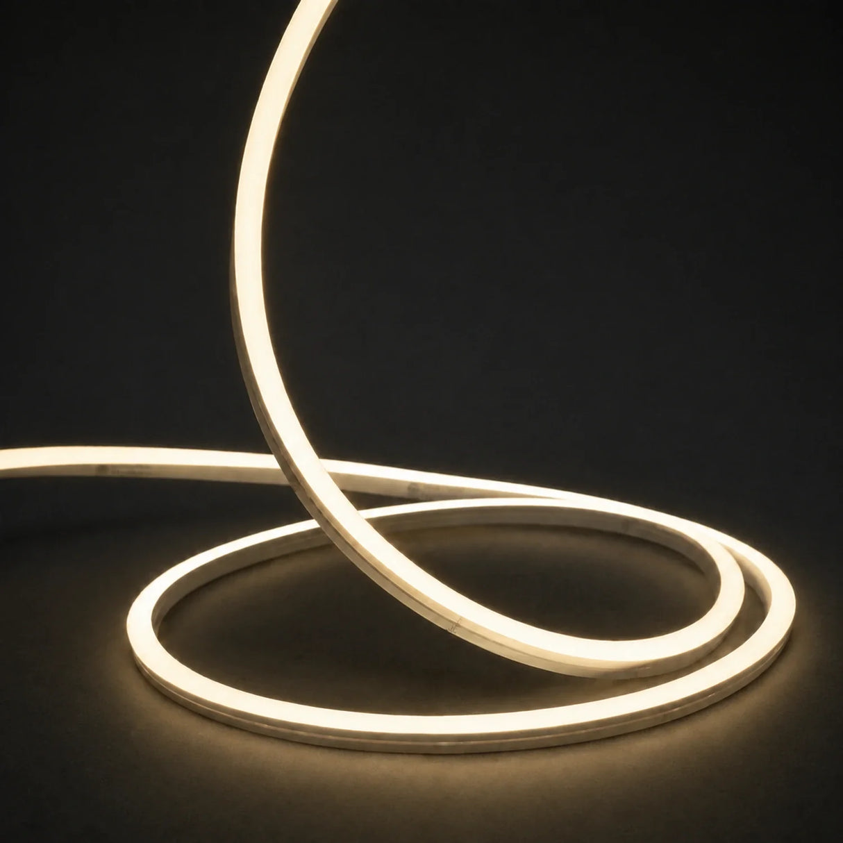 3000K side-bend Neon Flex raised in loops on a dark surface, colour-adjusted product photograph