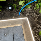 4000K side-bend Neon Flex outlining a timber garden edge, colour-adjusted installation illustration