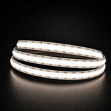 Daylight 5000K COB LED strip coil illuminated on a dark background, 24V DC and 10mm wide.