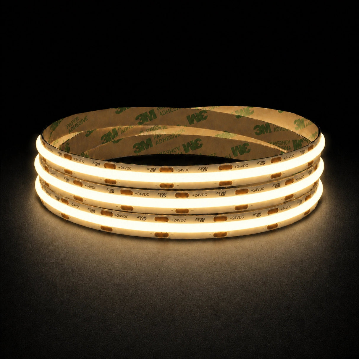 Warm White 2700K 24V 10mm COB LED strip shown illuminated in a coil on a dark background.