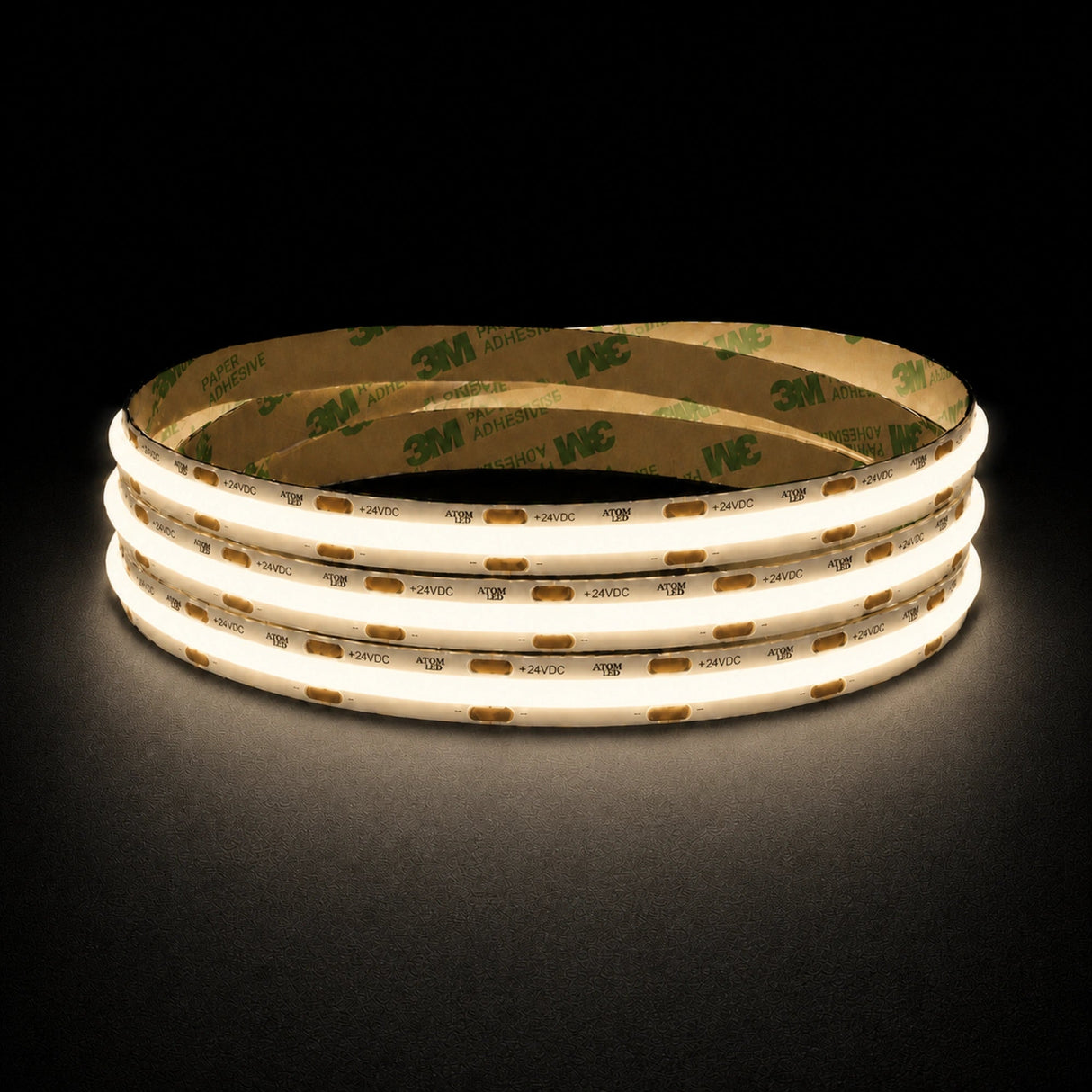 Warm White 3000K 24V 10mm COB LED strip shown illuminated in a coil on a dark background.