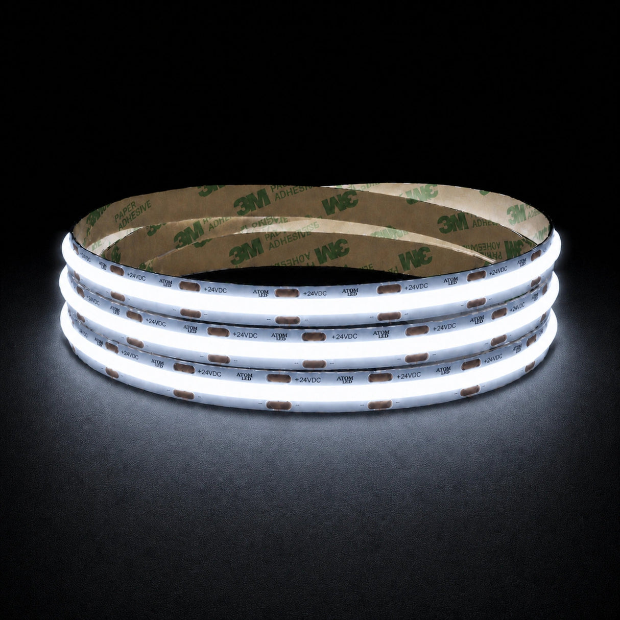 Cool White 6500K 24V 10mm COB LED strip shown illuminated in a coil on a dark background.