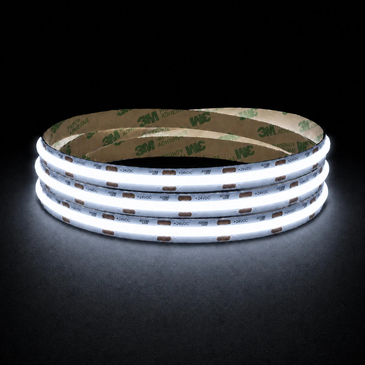 Cool White 6500K 24V 10mm COB LED strip shown illuminated in a coil on a dark background.