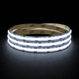 Cool White 6500K 24V 10mm COB LED strip shown illuminated in a coil on a dark background.