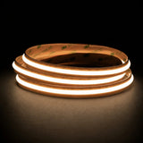 Warm White 3000K Free Cut COB LED strip coil illuminated on a dark background, 24V DC and 10mm wide.