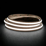 Daylight 5000K Free Cut COB LED strip coil illuminated on a dark background, 24V DC and 10mm wide.