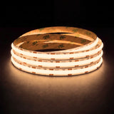 Warm White 3000K SCOB LED strip coil illuminated on a dark background, 24V DC and 10mm wide.