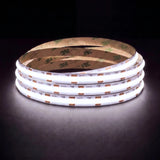 Daylight 5000K SCOB LED strip coil illuminated on a dark background, 24V DC and 10mm wide.