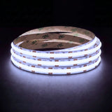 Cool White 6500K SCOB LED strip coil illuminated on a dark background, 24V DC and 10mm wide.