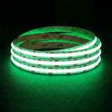 Green SCOB LED strip coil illuminated on a dark background, 24V DC and 10mm wide.