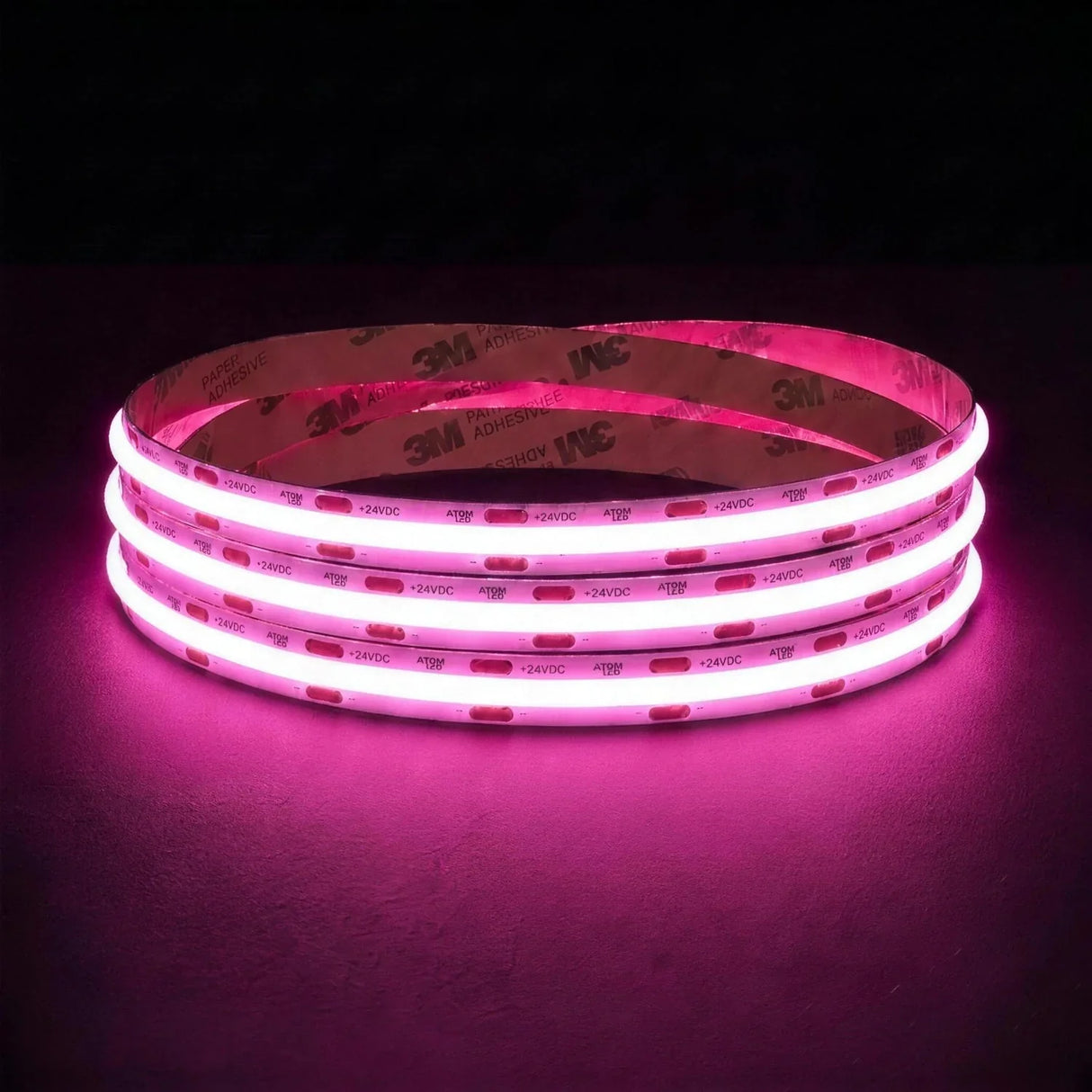 Pink SCOB LED strip coil illuminated on a dark background, 24V DC and 10mm wide.