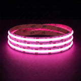 Pink SCOB LED strip coil illuminated on a dark background, 24V DC and 10mm wide.
