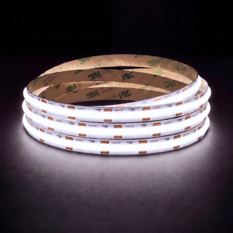 Daylight white 5000K SCOB LED strip coil illuminated on a dark background, 24V DC and 10mm wide, with copper connection pads
