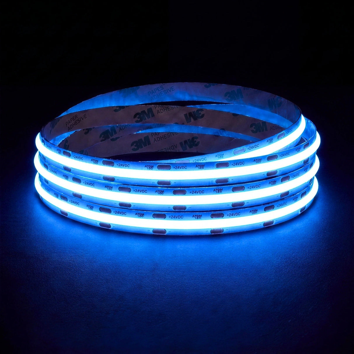 Blue SCOB LED strip coil illuminated on a dark background, 24V DC and 10mm wide, with copper connection pads