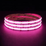 Pink SCOB LED strip coil illuminated on a dark background, 24V DC and 10mm wide, with copper connection pads