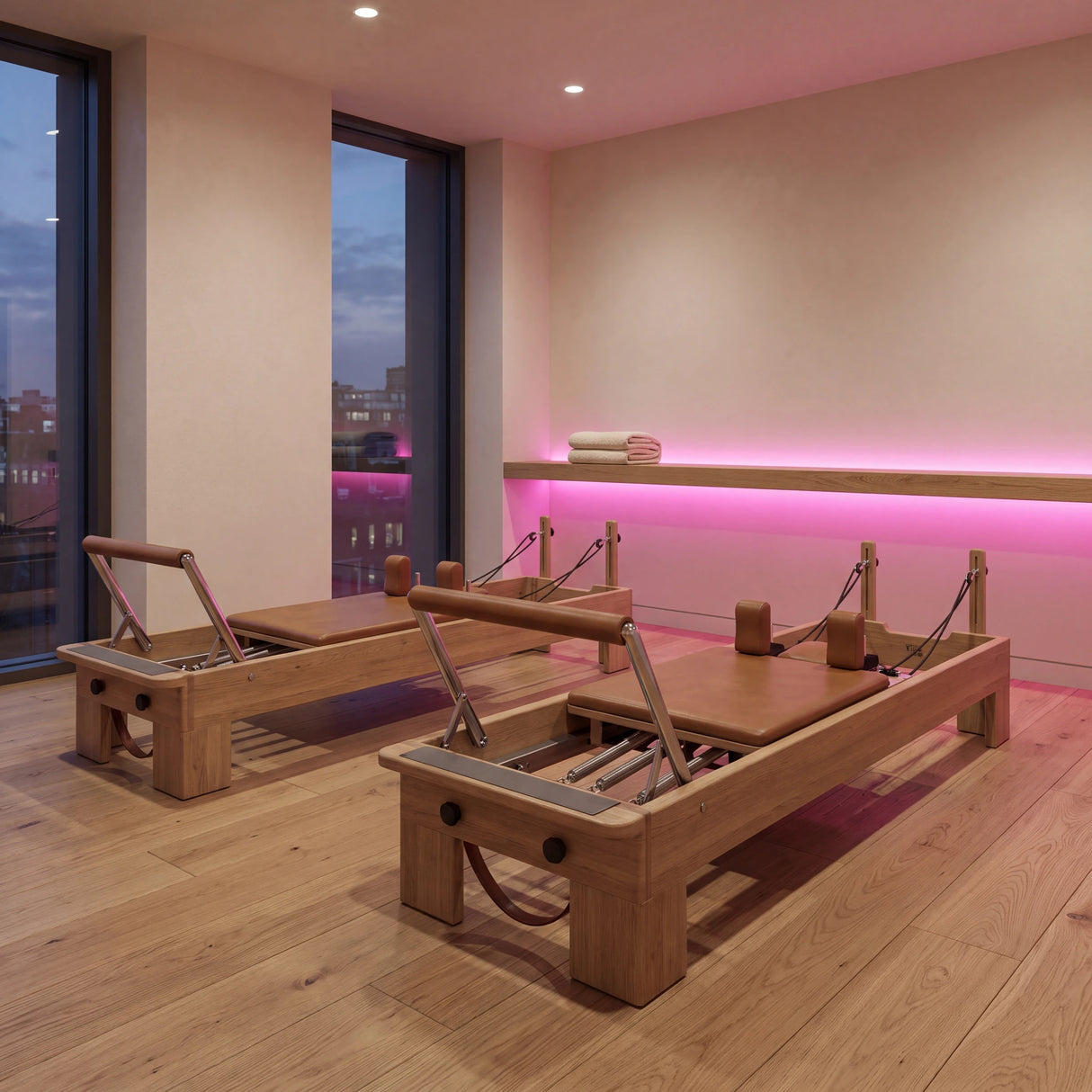 Pink SCOB LED strip accent lighting behind an oak ledge in a Pilates studio with two reformers; installation illustration.