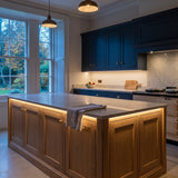 Warm White 3000K 24V 10mm COB LED strip installed beneath cabinets and around a British kitchen island; installation visual.
