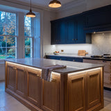 Daylight 5000K 24V 10mm COB LED strip installed beneath cabinets and around a British kitchen island; installation visual.