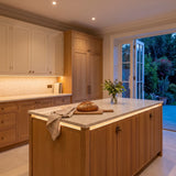 Warm White 2700K 24V 10mm free cut COB LED strip installed beneath cabinets and around a British kitchen island; installation visual.